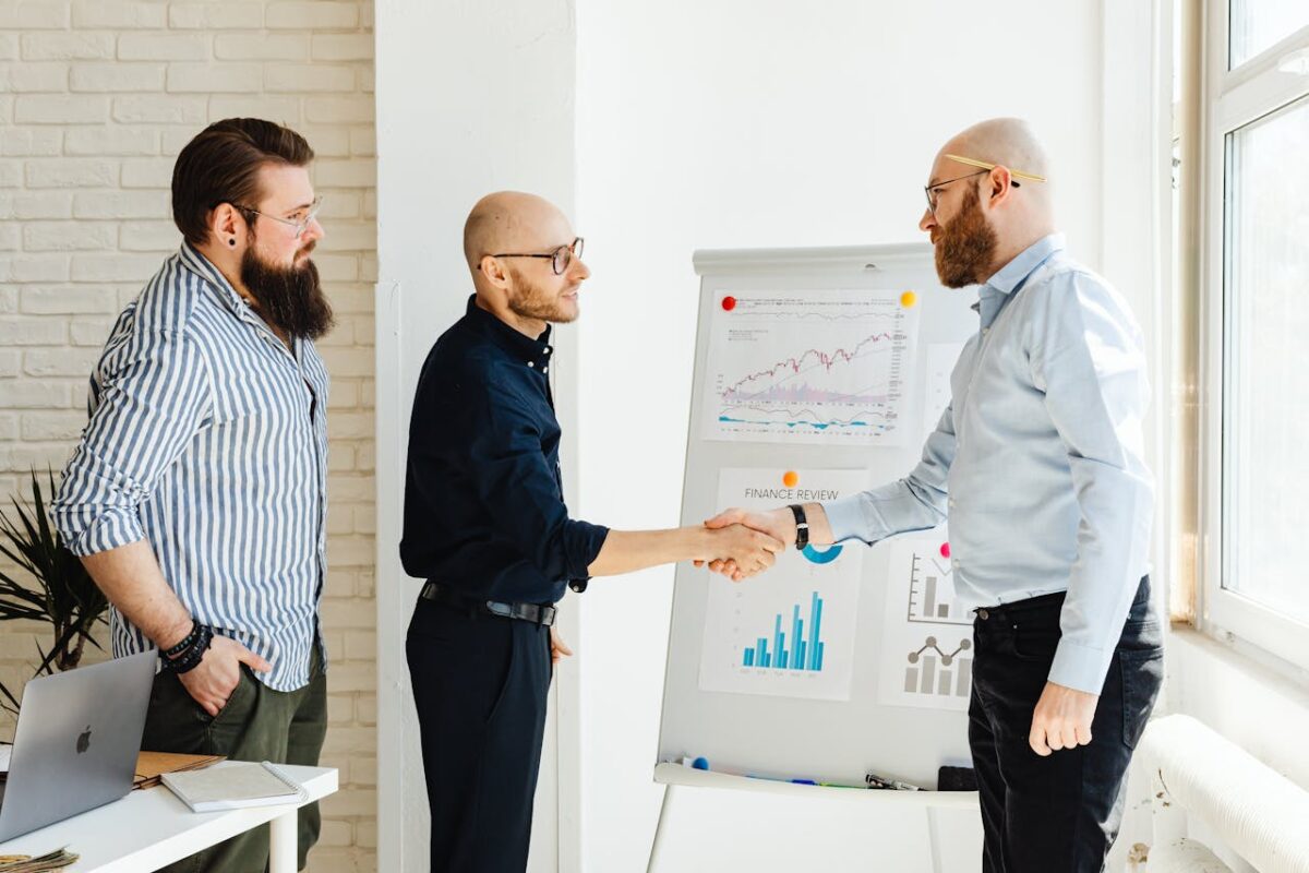 Three business colleagues engage in a productive meeting, exchanging ideas with data charts.